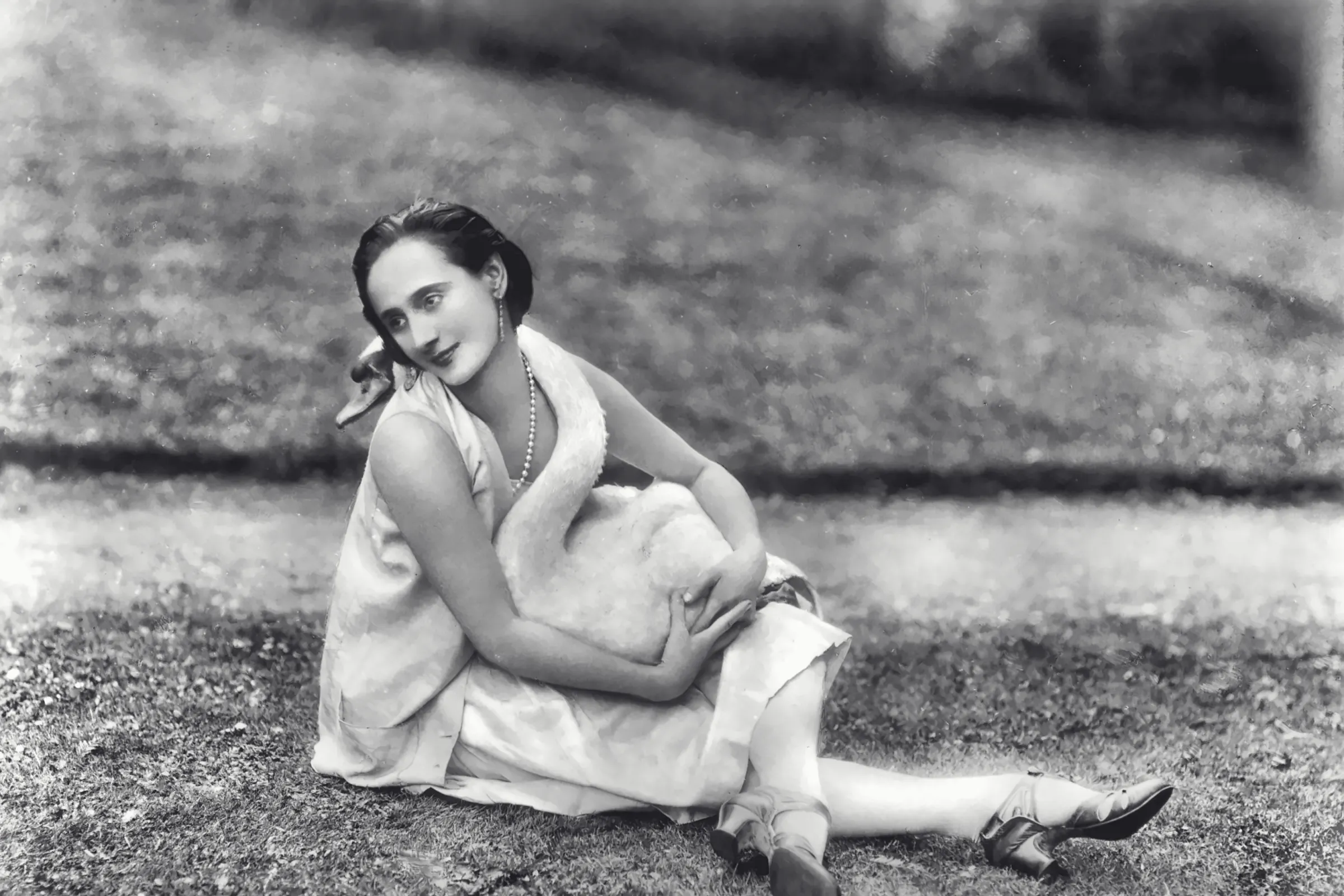Anna Pavlova sitting on the lawn with a white swan in her lap